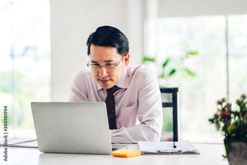 Asian man using laptop computer working and video conference online meeting with colleagues at home.Young creative man talk video call with business team.work from home concept Asian man using laptop computer working and video conference online meeting with colleagues at home.Young creative man talk video call with business team.work from home concept