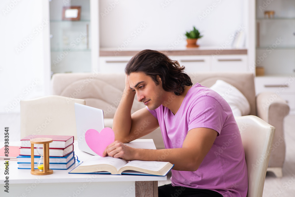 Male student in love preparing for exams in time management conc Male student in love preparing for exams in time management conc