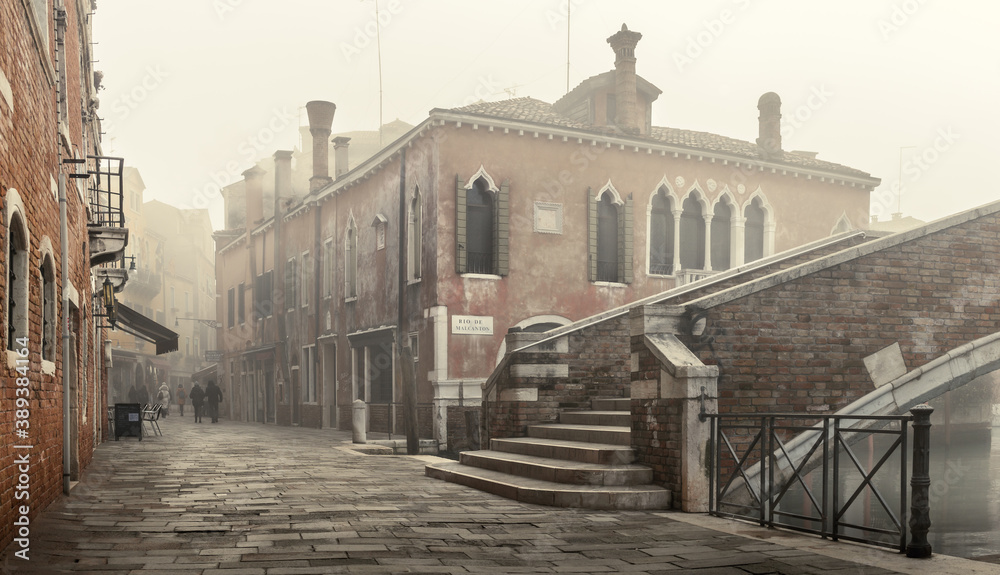 Old brick house with oriental windows on a foggy morning - Venice, Italy