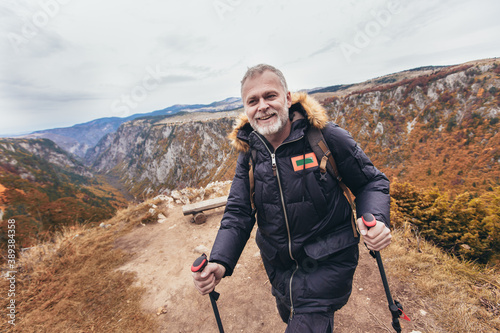 Happy mature man hiking in autumn