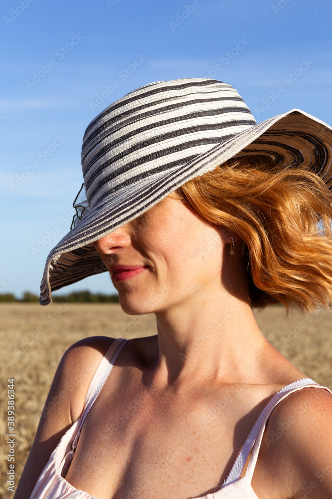 Young beauty woman with hat in the field