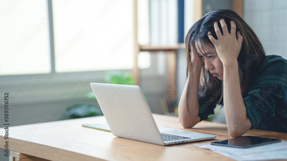 Asian women are working at home using their laptop...Work with stress Asian women are working at home using their laptop...Work with stress