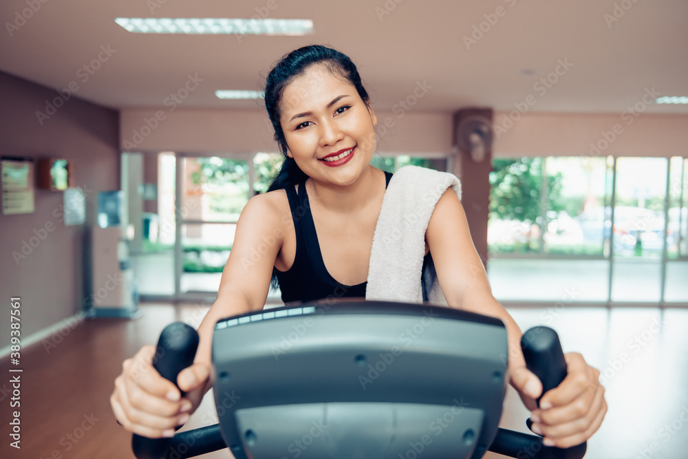 Sport Woman is Cycling Exercise in Fitness Club, Attractive Asian Woman
