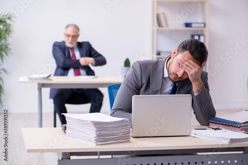 Old boss and his young assistant working in the office