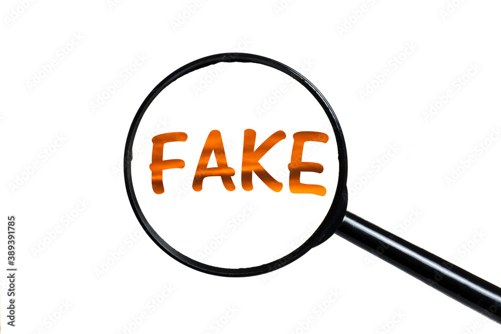 word fake and magnifying glass on white background. word fake and magnifying glass on white background.