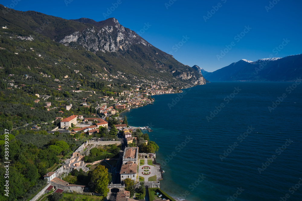 Panoramic view of the Villa in the town of Gargnano on Lake Garda Italy. High-altitude aerial view of the architecture on Lake Garda. Villa on Lake Garda in the background Alps and blue sky.