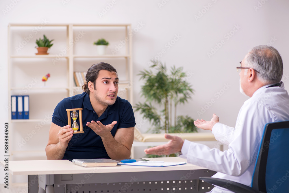 Young male patient visiting old doctor in time management concep Young male patient visiting old doctor in time management concep