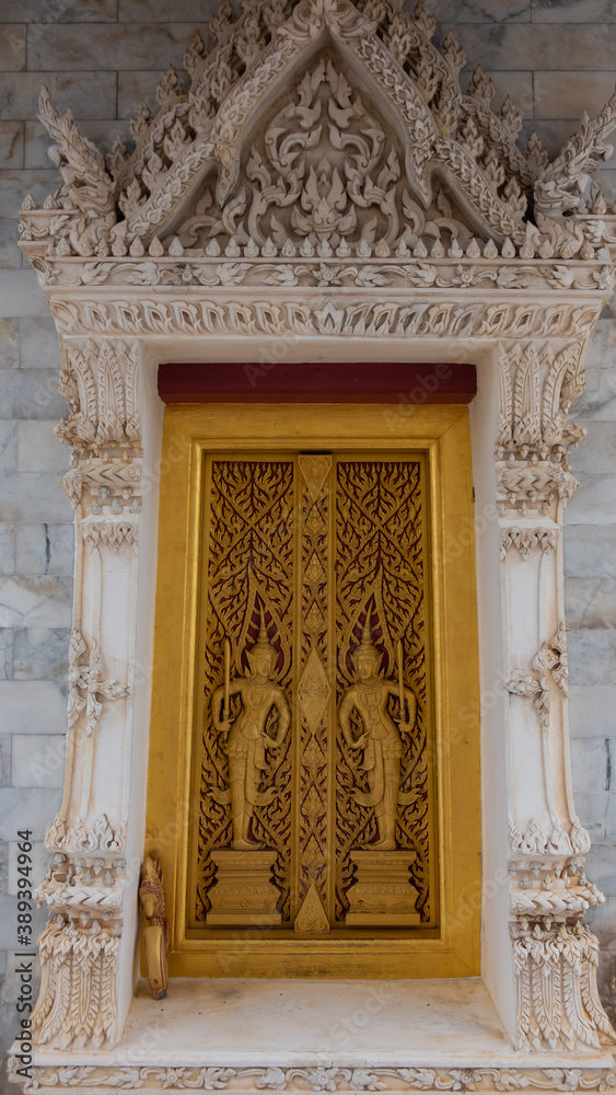 The gates of the temple church are carved with beautiful Thai patterns on Buddhism.