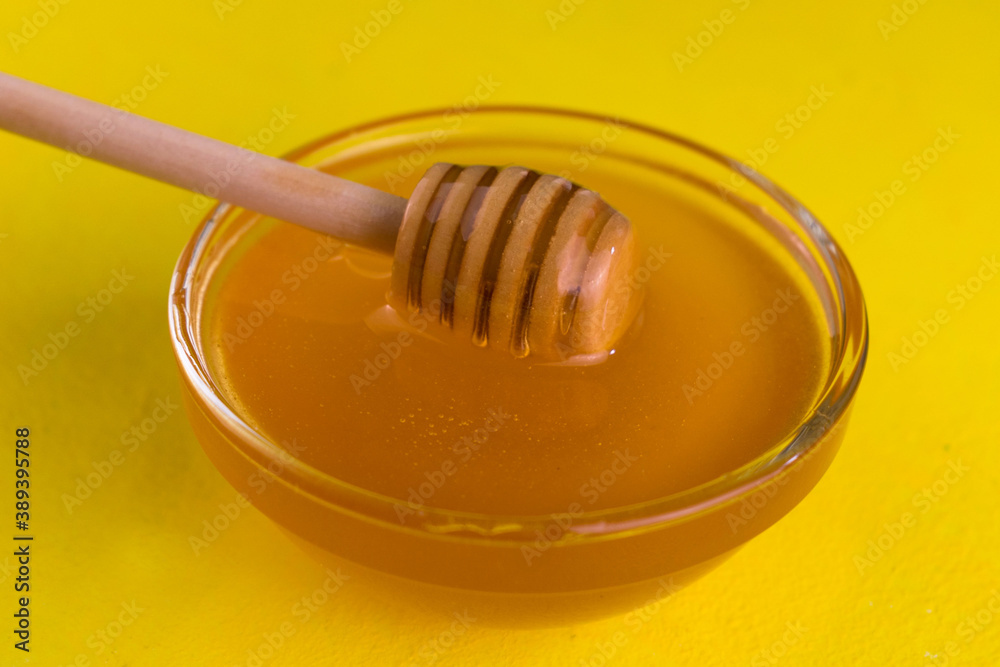 Floral honey in a bowl on a yellow background.
Close-up. Floral honey in a bowl on a yellow background.
Close-up.