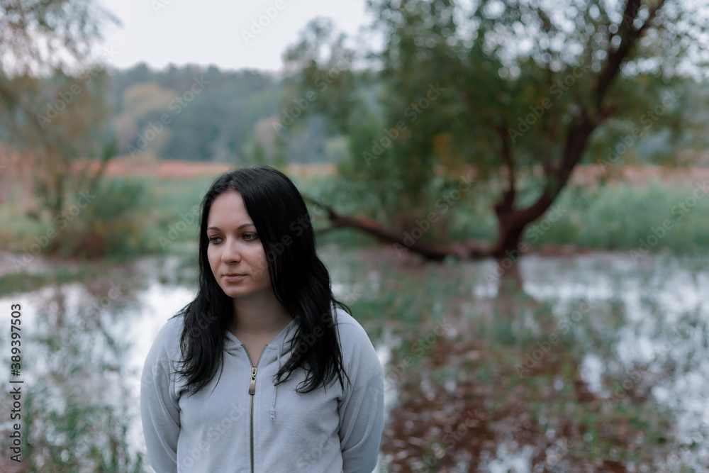 Sad woman stands on the background of the swamp Sad woman stands on the background of the swamp