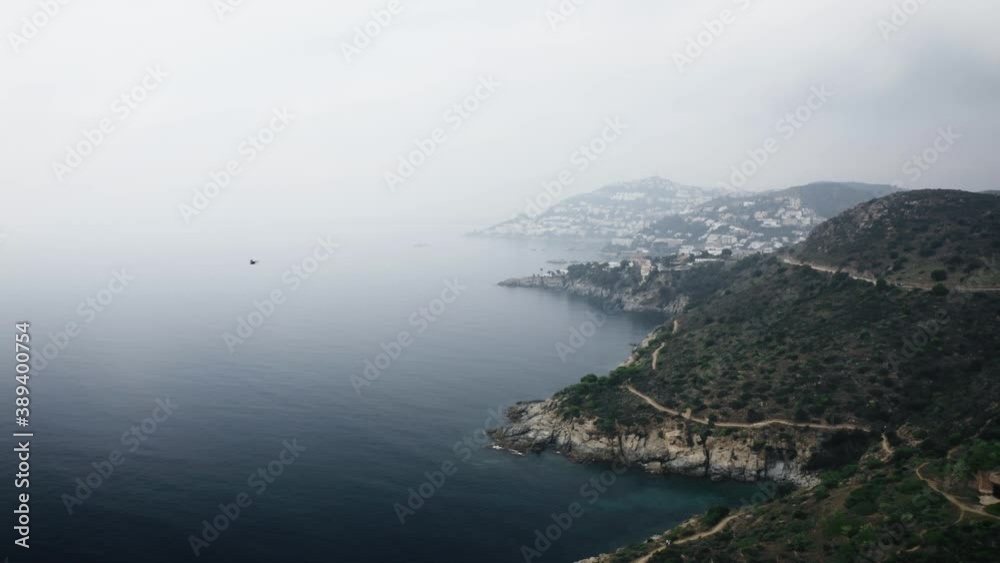 Drone video of coastal mountains on a cloudy day with fog in Roses, Girona, Spain Drone video of coastal mountains on a cloudy day with fog in Roses, Girona, Spain