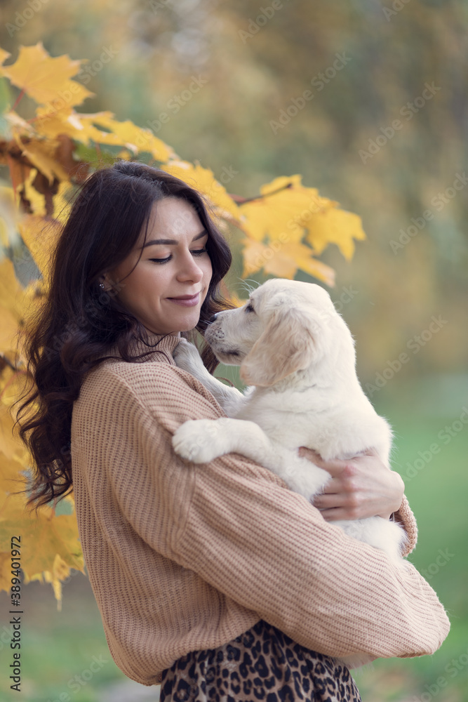 Beautiful brunette woman with her golden retriever puppy, autumn beautiful colors, emotions Beautiful brunette woman with her golden retriever puppy, autumn beautiful colors, emotions