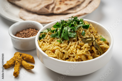 Kichari in a white plate on a light table near the condiments photo