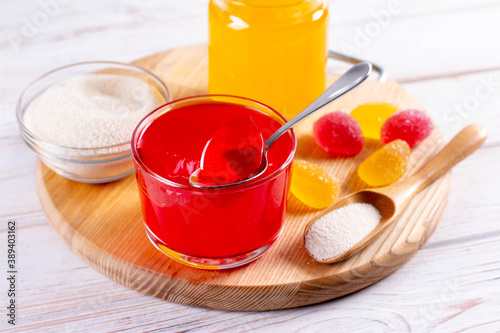 Gelling agents: gelatin, agar-agar or pectin powder with marmalade on wooden cutting board.