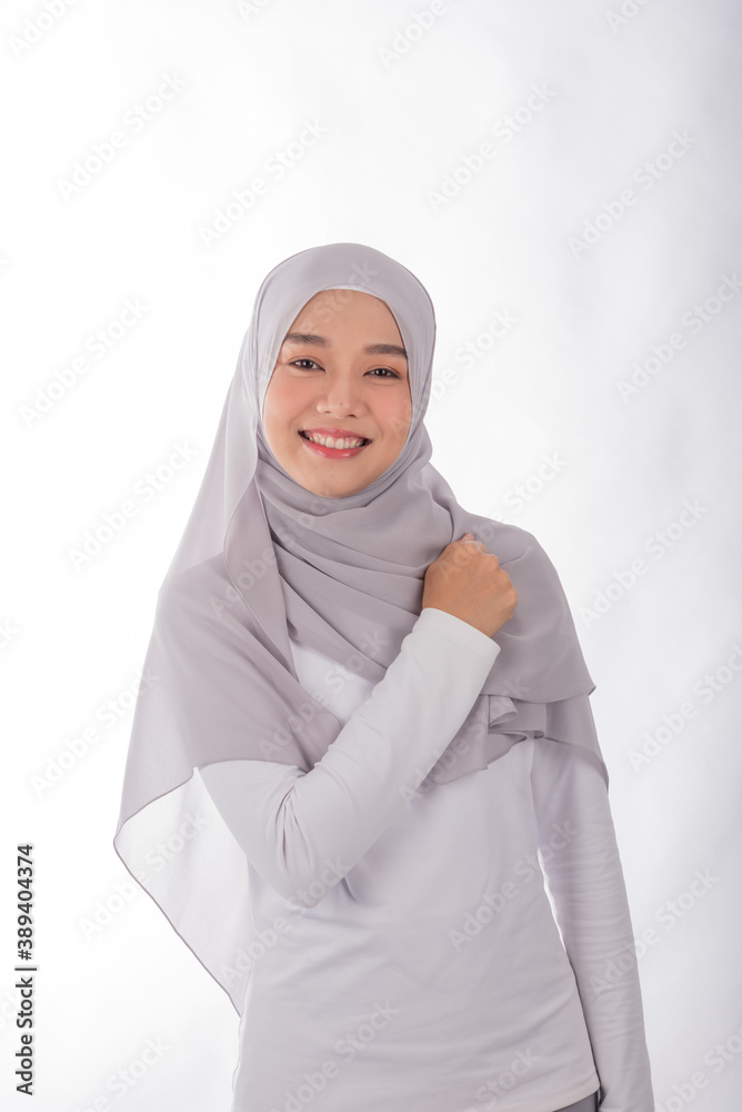 Portrait of Asian muslim woman smiling at camera and the right hand close to her left chest. Portrait of Asian muslim woman smiling at camera and the right hand close to her left chest.
