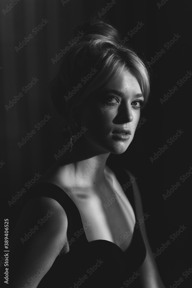Fototapeta Close up studio portrait of a pretty blonde woman in black top.