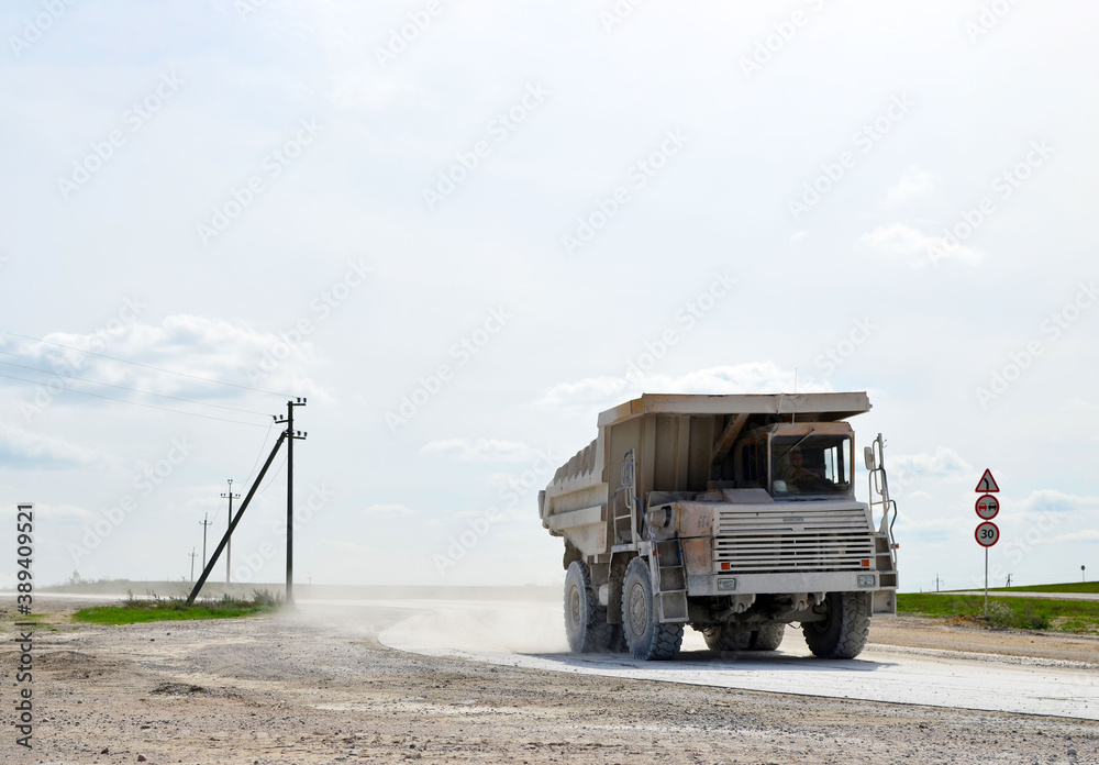 Big yellow dump truck working in the limestone open-pit. Loading and transportation of minerals in the chalk mining quarry. Belarus, Krasnoselsk, in the largest i chalk deposit, quarry 