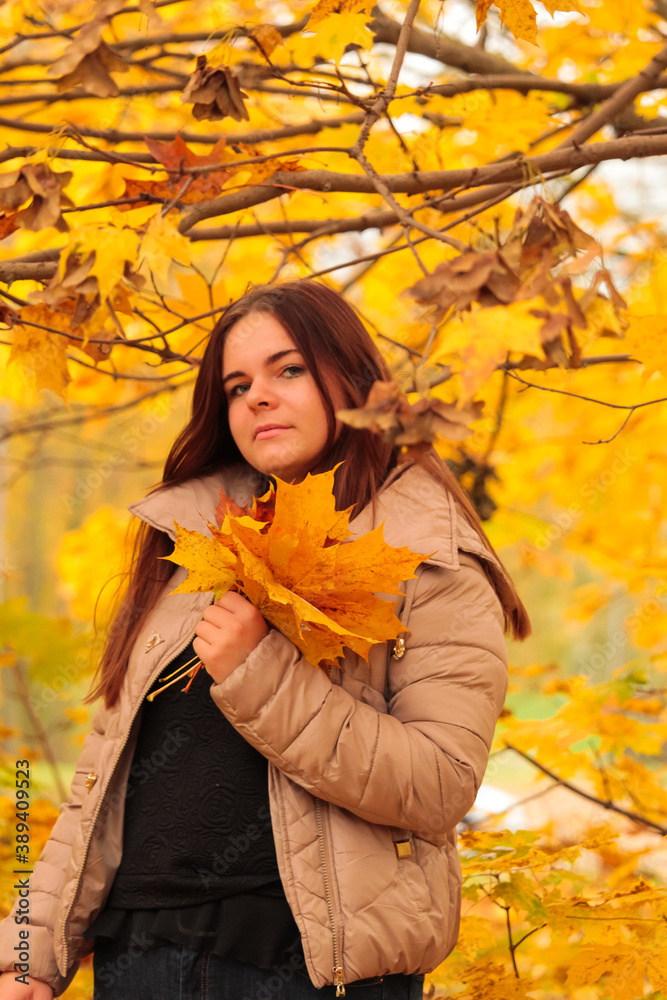 Young girl in autumn park with maple leaves Young girl in autumn park with maple leaves