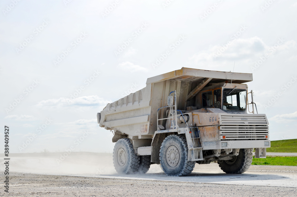 Big yellow dump truck working in the limestone open-pit. Loading and transportation of minerals in the chalk mining quarry. Belarus, Krasnoselsk, in the largest i chalk deposit, quarry 