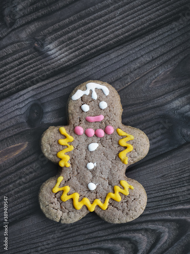 Gingerbread cookies in shape of man on dark wooden background