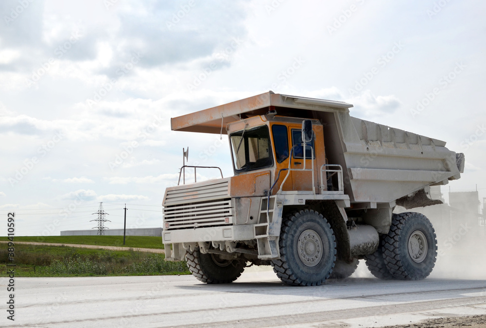 Mining truck transports chalk from open pit to an industrial plant for the needs of the construction industry and world markets. Loading and transportation of minerals in the limestone mining quarry
