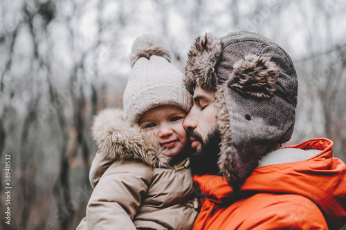 Handsome young dad and his little sweet daughter have fun outdoors in winter. Happy family spending time together. Family concept.