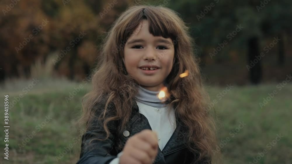 Girl holding sparklers in the fall forest Girl holding sparklers in the fall forest