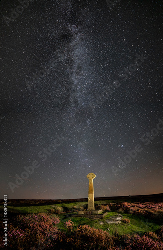 Milky way and foreground cross at North York Moors in portrait, Rosedale, UK.