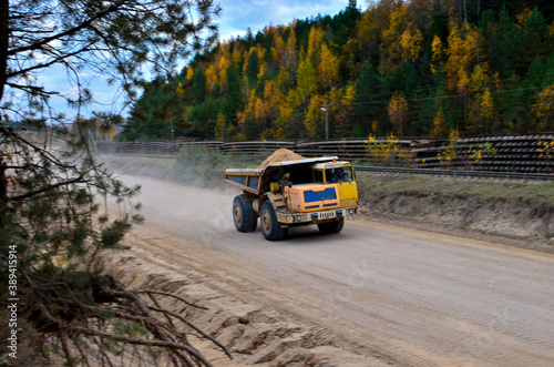 Heavy large quarry dump truck. Big wheels. The work of construction equipment in the mining industry. Production useful minerals. Sand transportation. Coal mine.