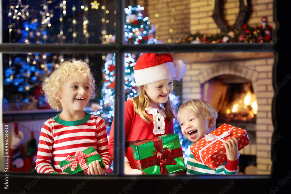 Child at Christmas tree. Kids at fireplace on Xmas Child at Christmas tree. Kids at fireplace on Xmas
