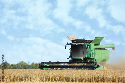 Modern combine harvester working in agricultural field