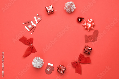 Winter background red. Stocking, gifts, winter tree, ribbon and bow in shape frame on red background for greeting card. Winter festive composition with copy space.