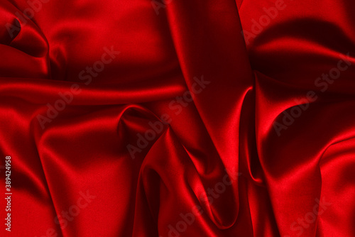 Red silk or satin luxury fabric texture can use as abstract background. Top view.