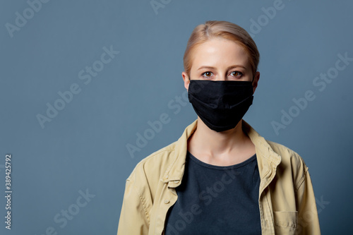 Woman in black face mask on grey background