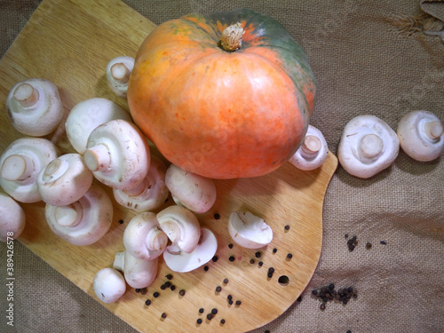 Pumpkin, champignons and black pepper isolated on wooden board and burlap