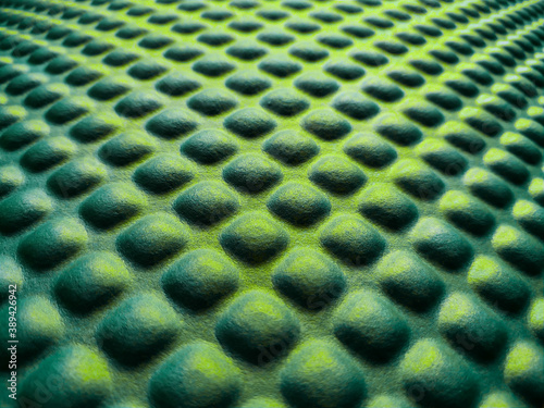 Green and yellow rubber mat texture closeup inside a gym. Fitness floor background with copy space. photo