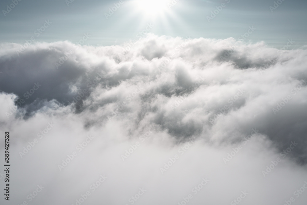 Fotografie Clouds in the sky with the sun shining upon