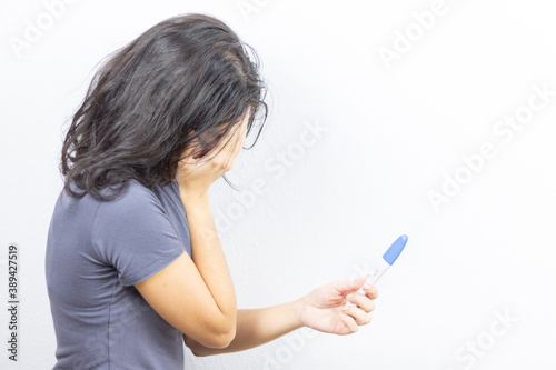 Girl with pregnancy test on white background