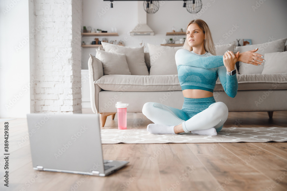 Woman athlete in sportswear runs online fitness workout marathon home. Concept web training with laptop Woman athlete in sportswear runs online fitness workout marathon home. Concept web training with laptop