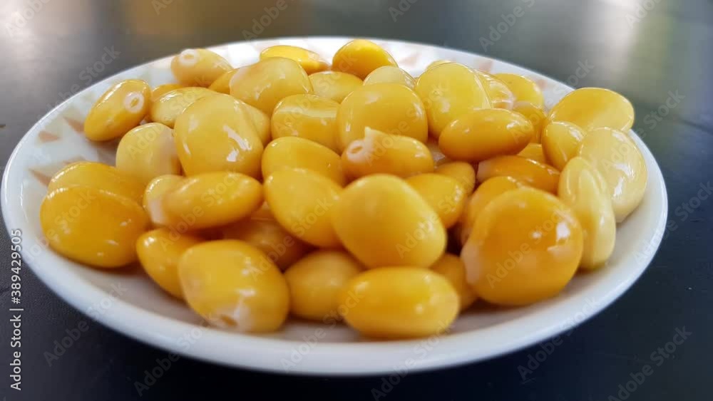 Woman hand taking lupin beans from plate to eat Woman hand taking lupin beans from plate to eat