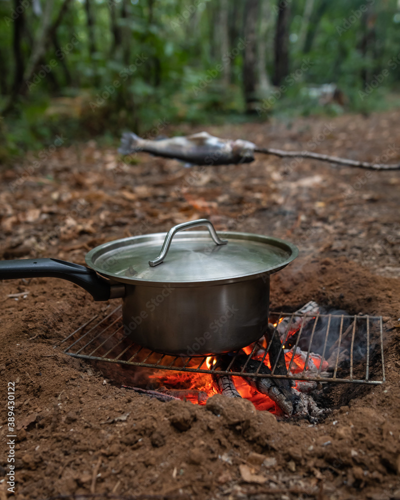 Trout and soup cooked over a wood fire in the forest