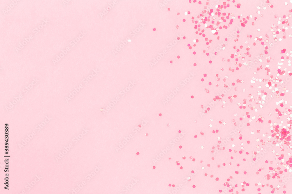 Pink background with sequins. Suitable for backdrop for your design. Top view, copy space.