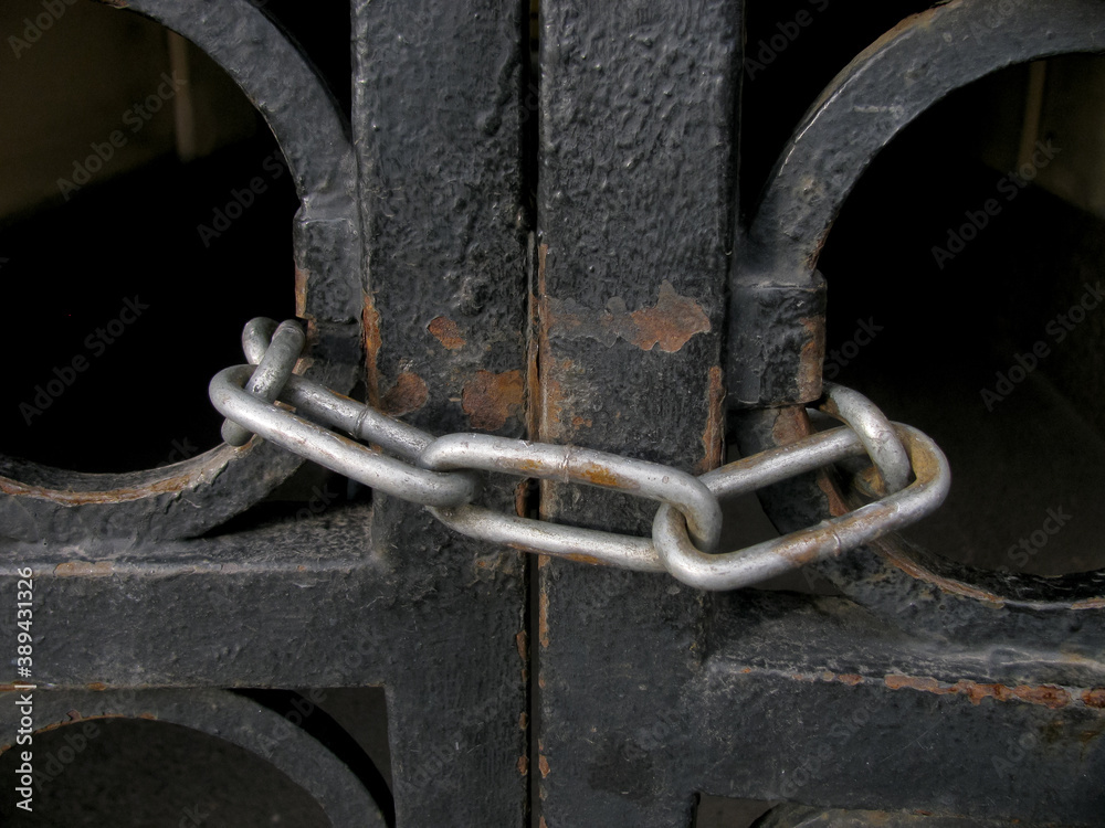 thick iron chain on the old black closed gate