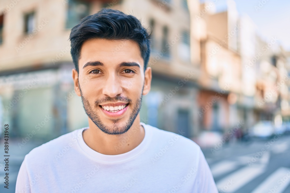 Young latin man smiling happy walking at the city. Young latin man smiling happy walking at the city.