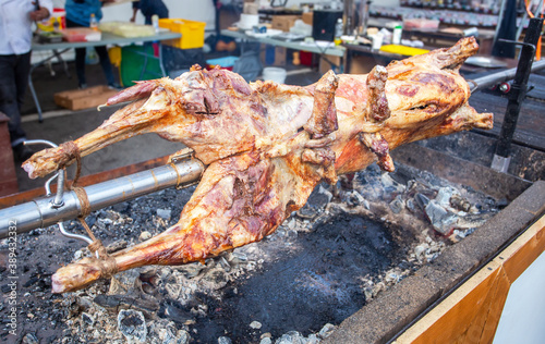 Cooking lamb carcass on a spit roasted on the open fire