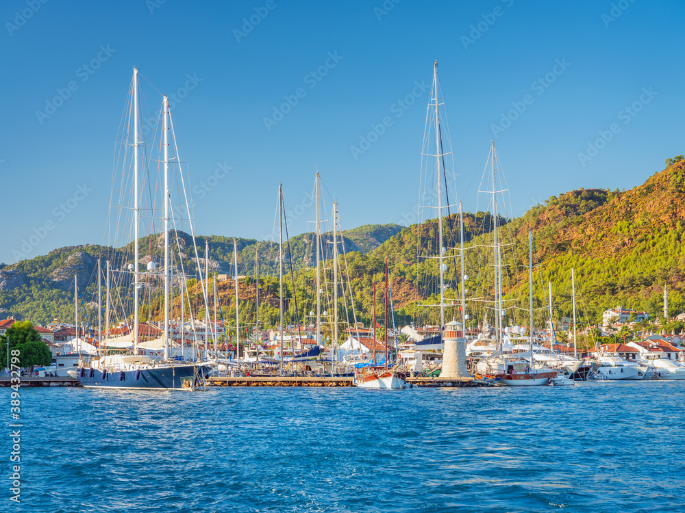 sea view to yacht marine with boats and little lighthouse under blue sky in summer day