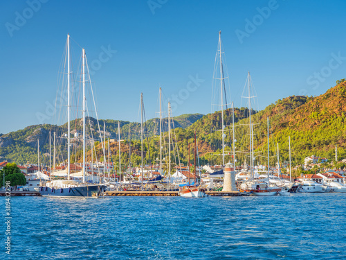 sea view to yacht marine with boats and little lighthouse under blue sky in summer day