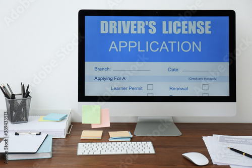 Computer with driver's license application form on table in office