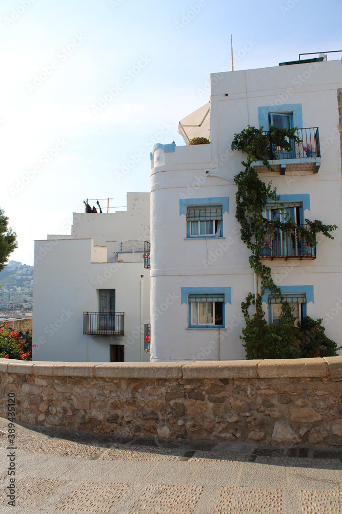 casa blanca con ventanas azules al lado de un camino de piedra