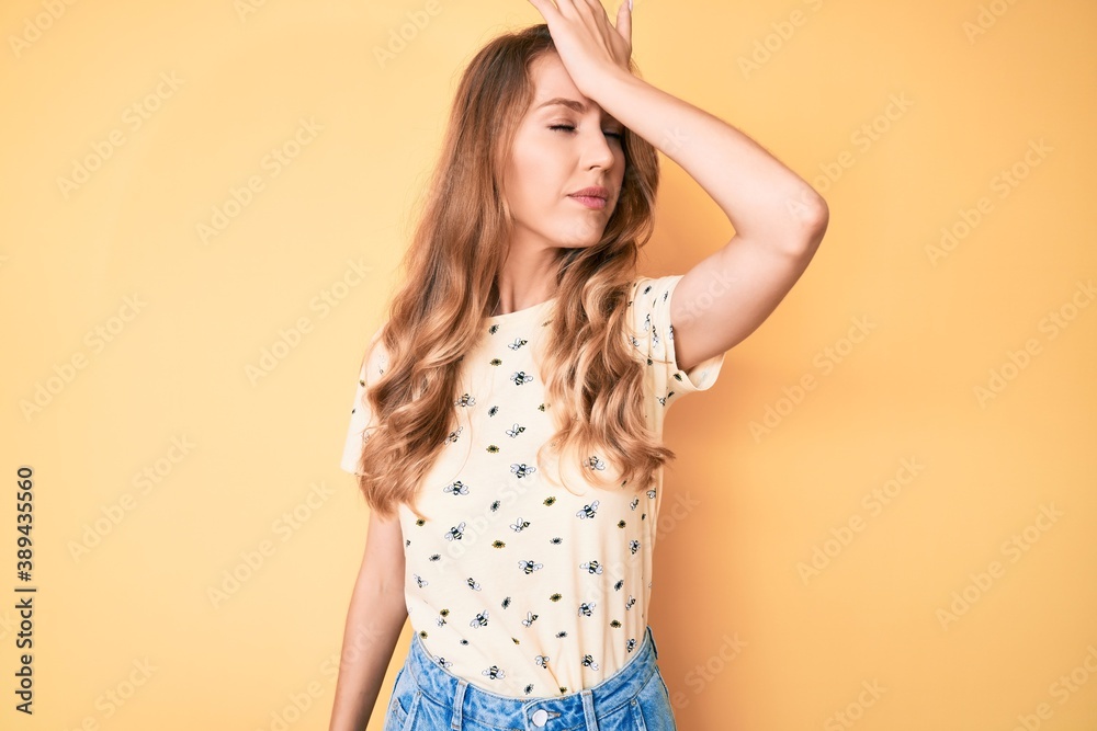 Obraz premium Young caucasian woman with blond hair wearing casual summer clothes surprised with hand on head for mistake, remember error. forgot, bad memory concept.